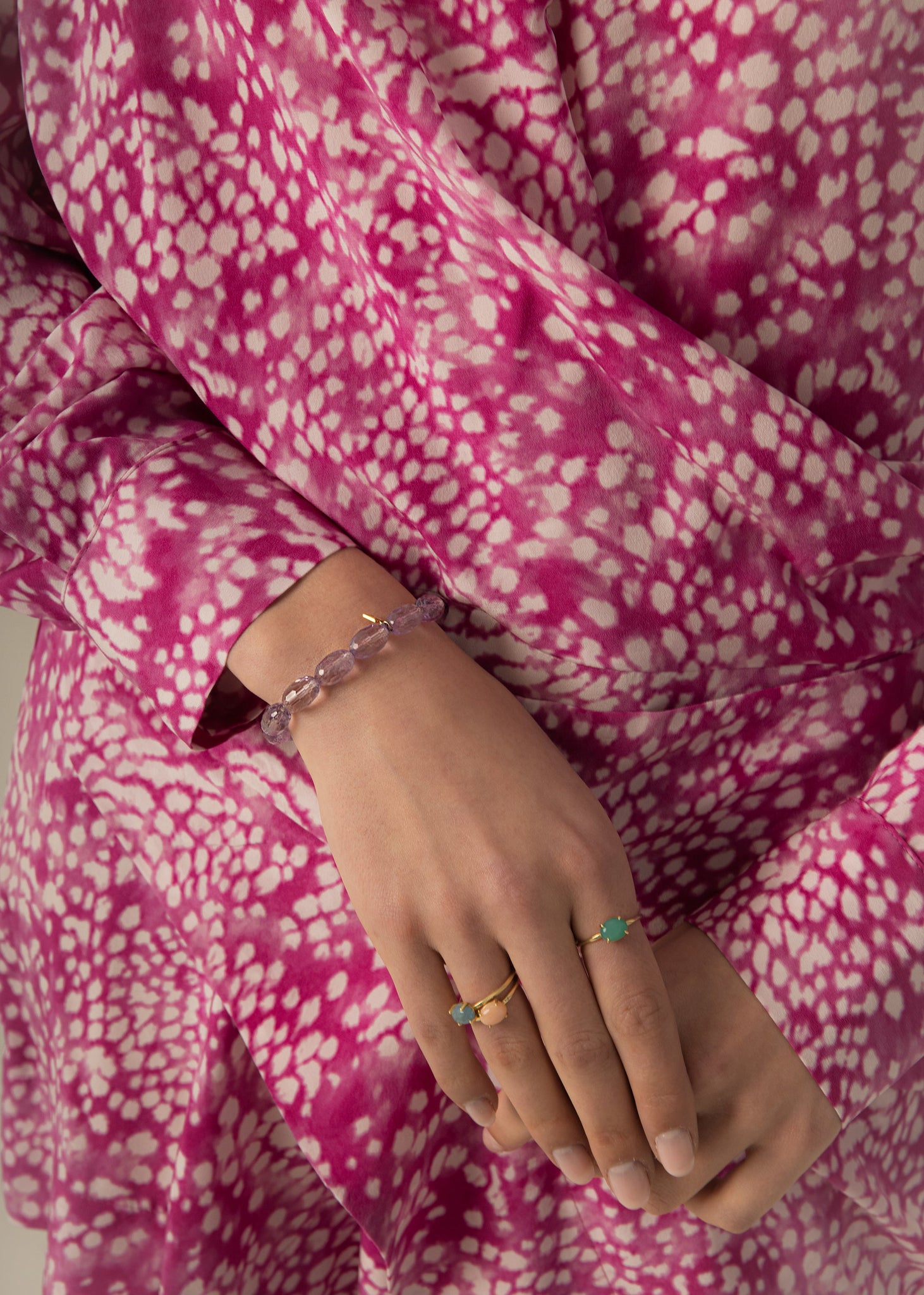 Kvinde med mange armbånd i boheme stil fra Carré. Armbåndene er sat med store ædelsten og perler, heriblandt Labradorit og Blå Safir.