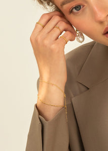 Kvinde med guldbelagte armbånd i figaro kæder fra carré jewellery 