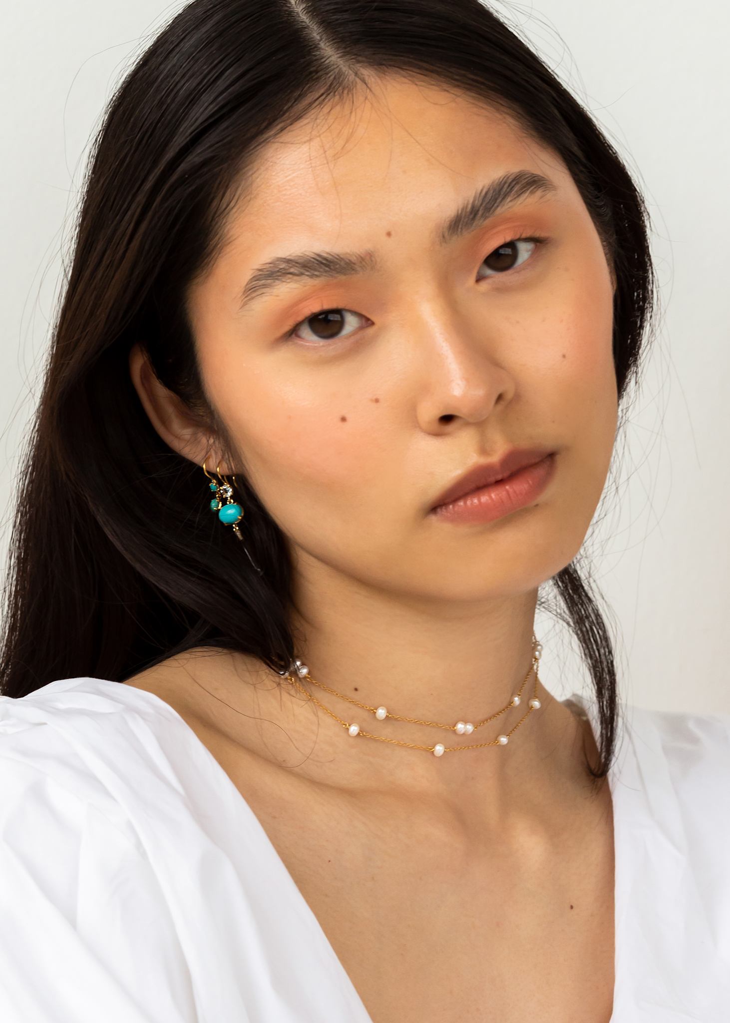 Kvinde med to perlehalskæder fra carré jewellery på tilbud i guldbelagt sterling sølv, perfekt gave til hende eller gave til konfirmanden