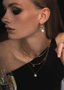 Ung kvinde med festtøj og halskæder i guld fra carré jewellery på udsalg med gyldne rutil kvarts ædelsten 