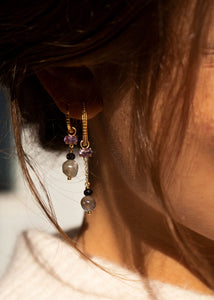 Kvinde med hoops og charms fra carré jewellery med en antik inspireret ørering hoop i guld 