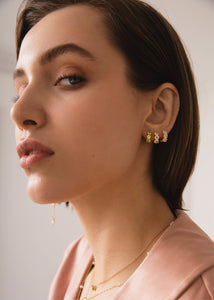 Kvinde med tre guld huggie hoops fra carré jewellery med peridot, rosa kvarts og månesten