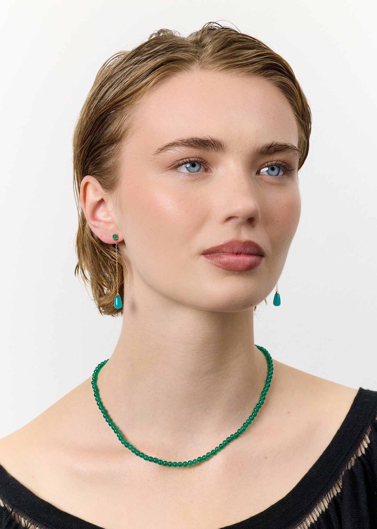 Ung kvinde med halskæde håndlavet i københavn med majs fødselssten, grøn agat ædelsten og lange hængeøreringe i guldbelagt sølv med grøn agat og amazonit ædelsten