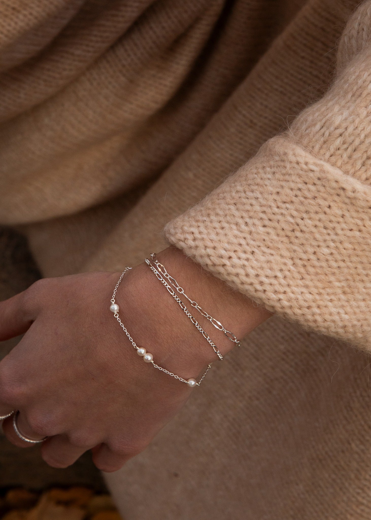 Kvinde med perlearmbånd og figaro armbånd i sterling sølv fra carré jewellery 
