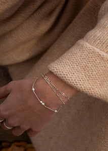 Kvinde med perlearmbånd og figaro armbånd i sterling sølv fra carré jewellery 