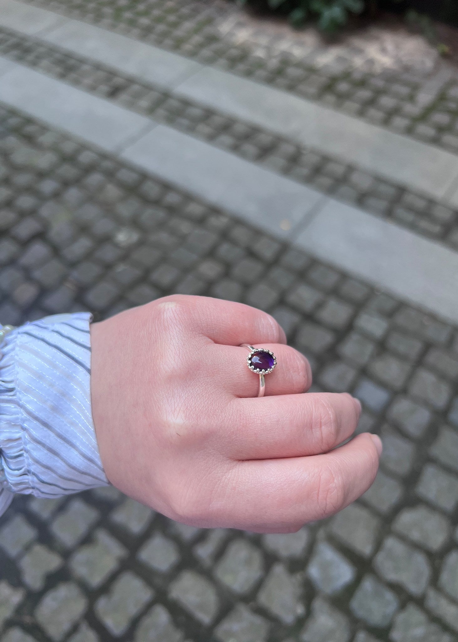 kvindehånd med lana ring i sterling sølv fra carré jewellery med en ametyst ædelsten 