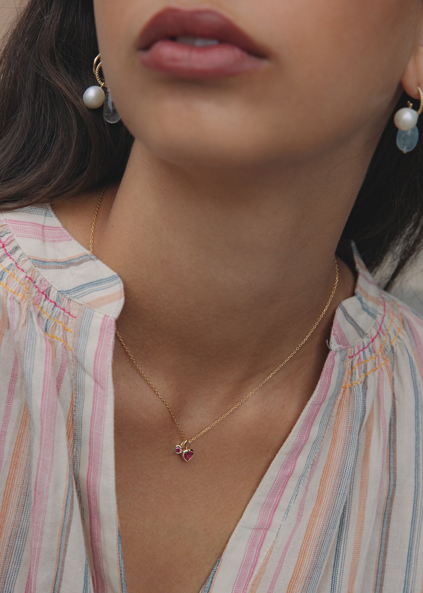 Kvinde med hjertevedhæng til halskæder i ægte guld med lyserøde turmalin ædelsten til kvinder på en guld ankerkæde fra carré jewellery