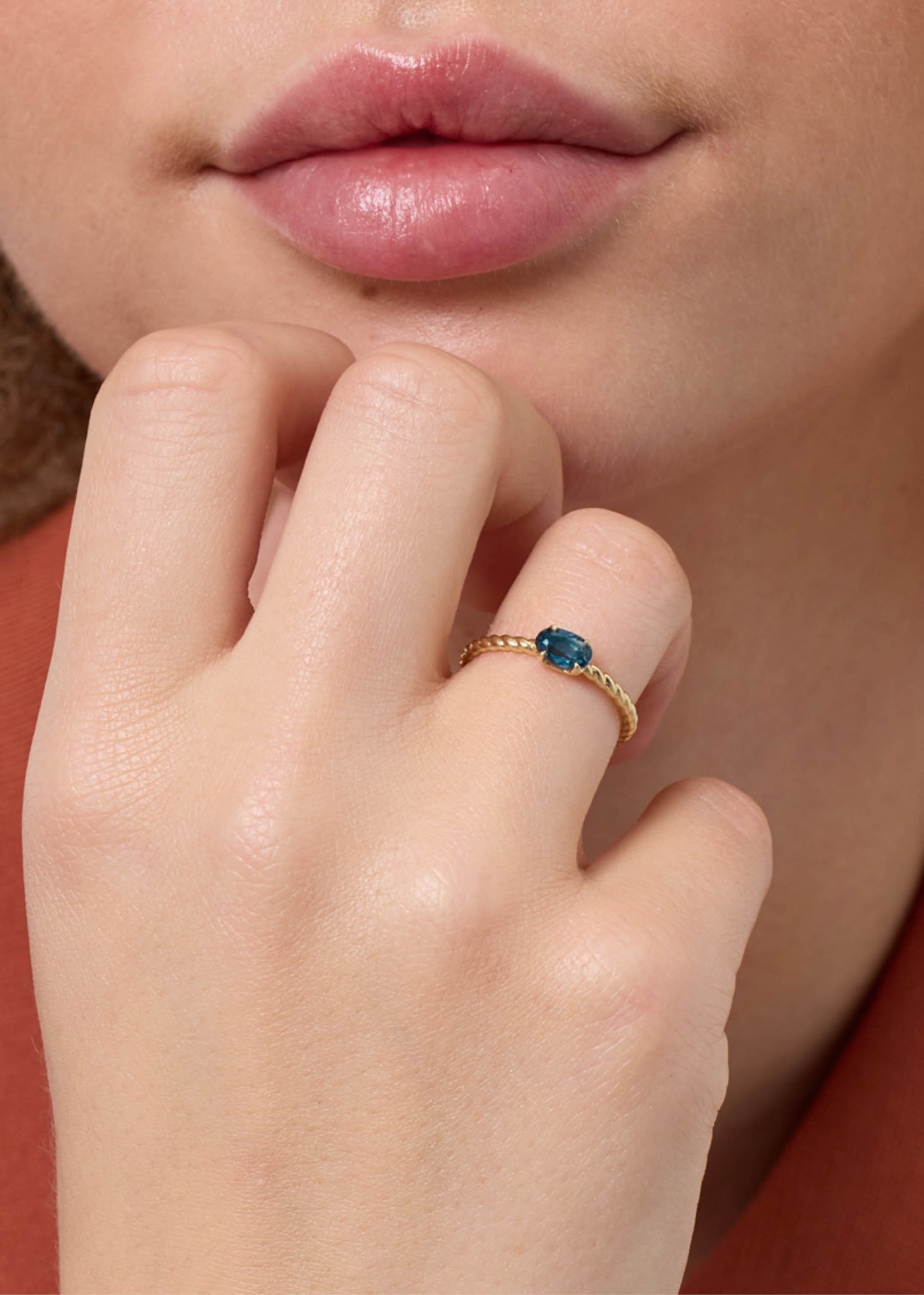 elegant ring i ægte guld med flettet ringskinne og en ovalslebet london blå topas ædelsten 